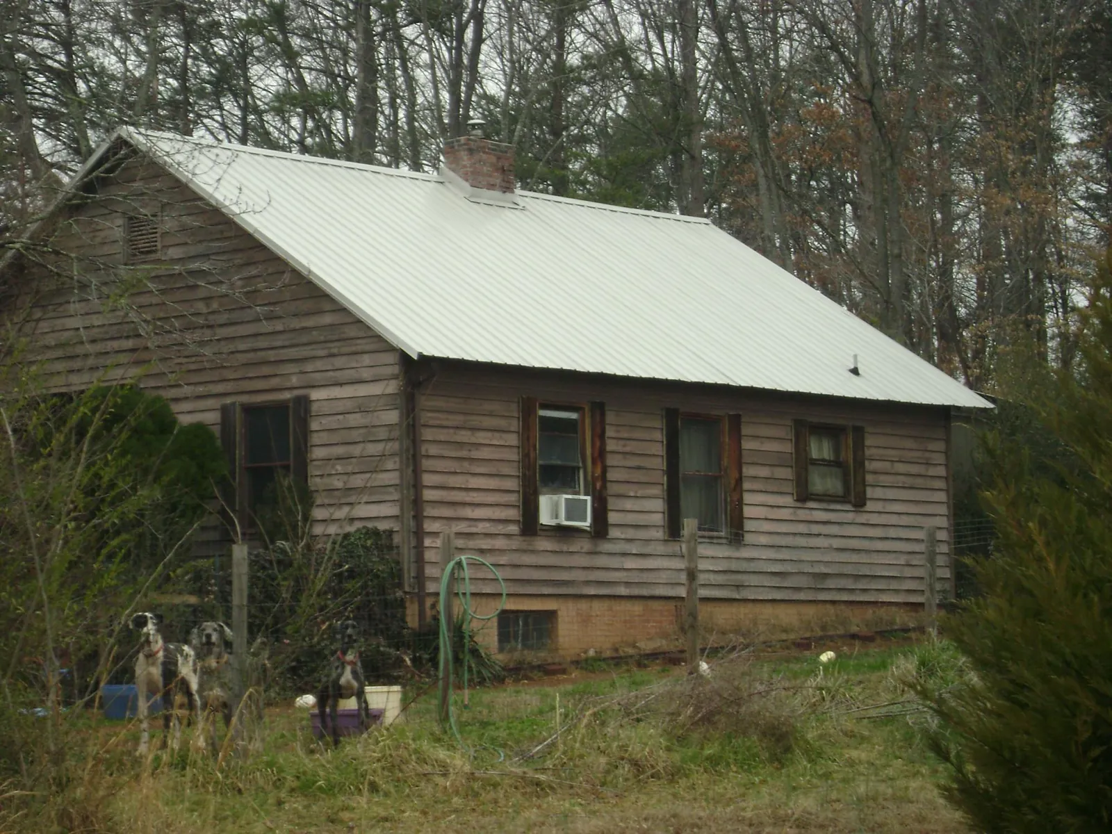 White metal roof on an old wood sided farmhouse, from a Metal Roof Installation job in Portage